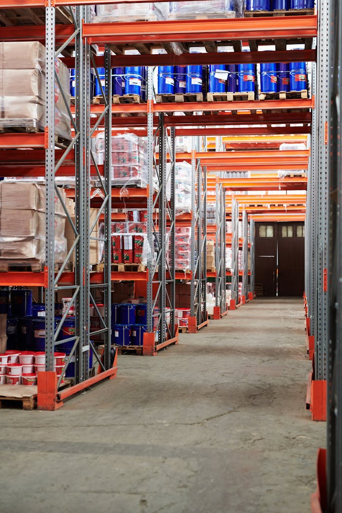 our-services-2 Industrial warehouse interior with organized shelves stacked with packages and goods.